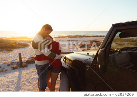 Couple with car in love at the beach 62034209