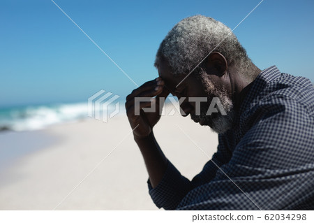 Old man reading book at the beach 62034298