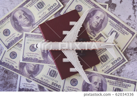 Airplane model and passport on dollars Airplane model and passport on dollars 62034336