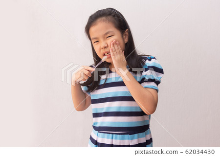 asian girl have a toothache holding toothbrush 62034430