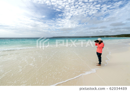 Female photographer on New Caledonia Loyalty Islands Lifou Island Champagne Beach 62034489
