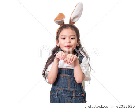 Little cute girl wearing rabbit ears and acting like a rabbit on white background. 62035639
