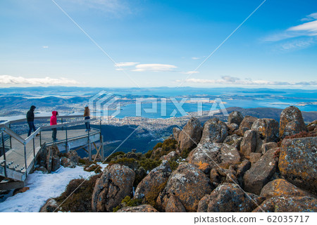 Tourist standing on the view point and looking the the panorama view of Hobart the capital city of Tasmania, Australia from Mount Wellington. 62035717