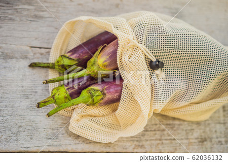 Eggplant in a reusable bag on a stylish wooden kitchen surface. Zero waste concept Eggplant in a reusable bag on a stylish wooden kitchen surface. Zero waste concept 62036132