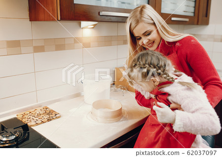 Cute family prepare the breakfest in a kitchen Cute family prepare the breakfest in a kitchen 62037097