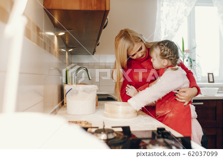 Cute family prepare the breakfest in a kitchen Cute family prepare the breakfest in a kitchen 62037099