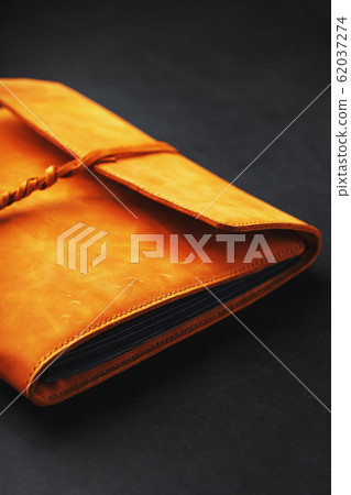 The leather cover of the album is made of brown The leather cover of the album is made of brown 62037274