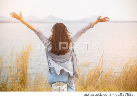 Back view of woman sit on the side of road. Back view of woman sit on the side of road. 62037622
