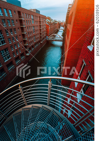 Spiral staircases in the old Warehouse District from canal side with red brick buildings of Speicherstadt in Hamburg. Blue hour Spiral staircases in the old Warehouse District from canal side with red brick buildings of Speicherstadt in Hamburg. Blue hour 62038916