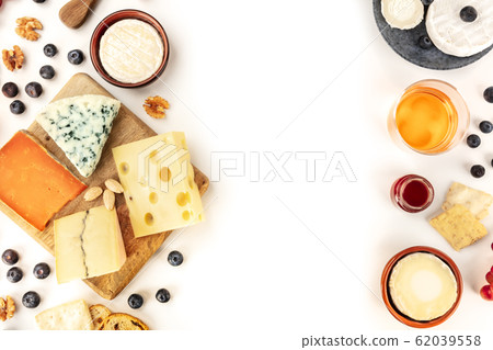 Cheese design, an overhead shot on a white background with a place for text. A variety of cheeses with wine and fruits, forming a frame for copyspace Cheese design, an overhead shot on a white background with a place for text. A variety of cheeses with wine and fruits, forming a frame for copyspace 62039558
