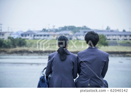 High school couple sitting on the riverbank 62040142