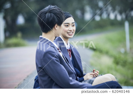 High school couple sitting on the riverbank 62040146