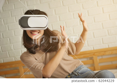 happy woman enjoying, playing VR Virtual Reality 62044229