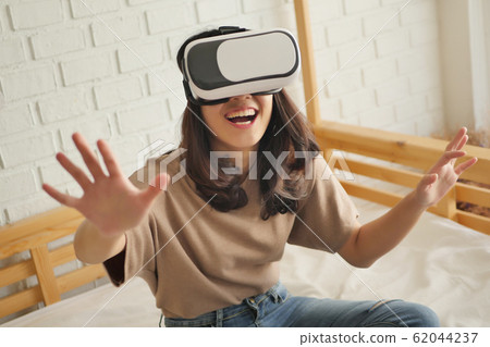 happy woman enjoying, playing VR Virtual Reality 62044237