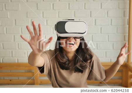 happy woman enjoying, playing VR Virtual Reality 62044238