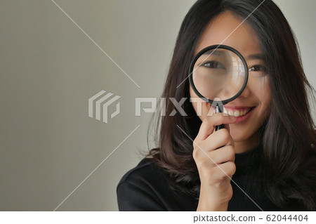 woman searching, viewing, finding with magnifying 62044404