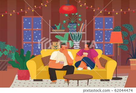 Couple Sitting on Sofa Eating Popcorn on Holidays 62044474