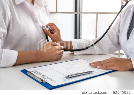 Female doctors perform a pulse examination using a stethoscope. Initial health check up at the hospital Concepts of treatment and good health 62045952