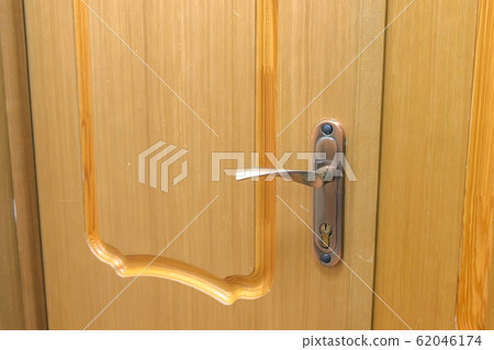 Wooden door with handle and lock, closeup view. Wooden door with handle and lock, closeup view. 62046174