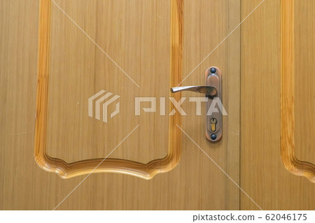 Wooden door with handle and lock, closeup view. Wooden door with handle and lock, closeup view. 62046175
