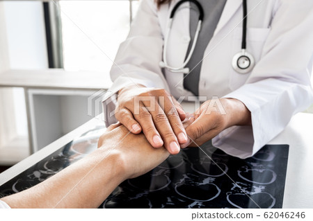 The female doctor uses a friendly hand to hold the hand of the patient to give confidence after the x-ray and advise on health care. Medical concepts and good health 62046246