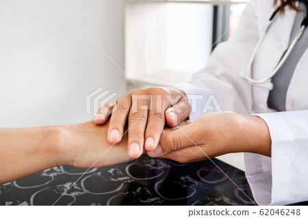 The female doctor uses a friendly hand to hold the hand of the patient to give confidence after the x-ray and advise on health care. Medical concepts and good health 62046248
