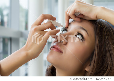 woman using eye drop, eye lubricant to treat dry 62046752