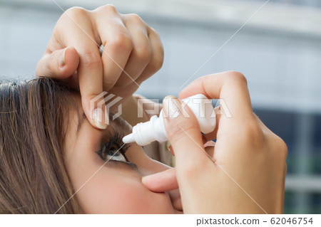 woman using eye drop, eye lubricant to treat dry 62046754