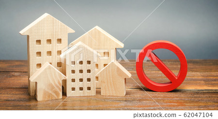 Wooden houses and a prohibition sign. Inaccessible and expensive housing. Restrictions and a ban on the construction of buildings. Interdictions within settlements. Inaccessibility Index Wooden houses and a prohibition sign. Inaccessible and expensive housing. Restrictions and a ban on the construction of buildings. Interdictions within settlements. Inaccessibility Index 62047104