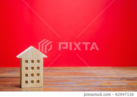 Miniature wooden house on a red background. Sweet Home concept. Buying and selling real estate. Affordable housing for young families. Apartments for rent. Business, mortgage, money. Copy space 62047116