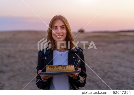 Young beautiful caucasian girl holding cake in her Young beautiful caucasian girl holding cake in her 62047294
