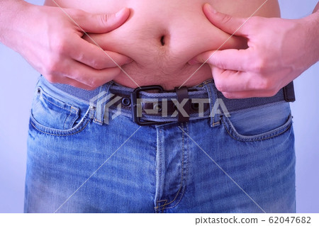 Man touches his flabby fat naked stomach, closeup view. Man touches his flabby fat naked stomach, closeup view. 62047682