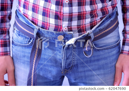 Man hardly buckles the belt of the jeans, pulling the stomach, hands closeup. 62047690