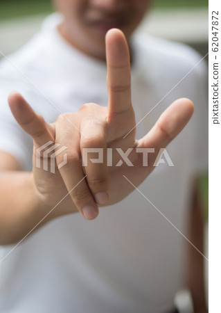 man with love or rock hand gesture; asian man 62047872