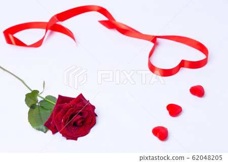 Red rose, ribbon and hearts on a white background. Valentine's Day, Birthday, Mother's Day, International Women's Day. Close-up, selective focus. 62048205