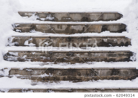 Staircase on the street in the snow and steps marked with snow with traces of people. Staircase on the street in the snow and steps marked with snow with traces of people. 62049314