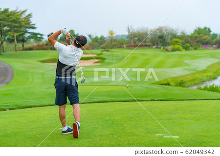 Man Golfer Hitting Ball with Club on Beatuiful Golf Course. Man Golfer Hitting Ball with Club on Beatuiful Golf Course. 62049342