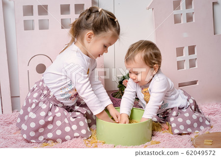 Two sisters 1 and 3 years old girls sits on the 62049572