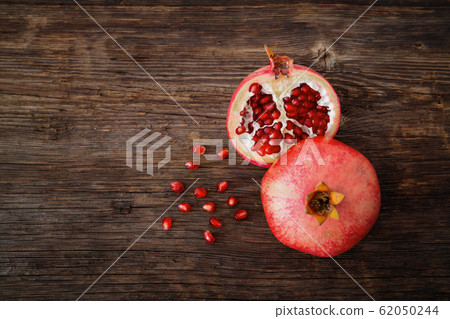 Ripe and fresh pomegranate peeled and ready for eat on wooden beackground Ripe and fresh pomegranate peeled and ready for eat on wooden beackground 62050244