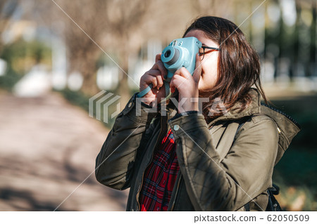 Teenage girl is walking and photographing in her vacation. Tourist, hobby concept. Teenage girl is walking and photographing in her vacation. Tourist, hobby concept. 62050509