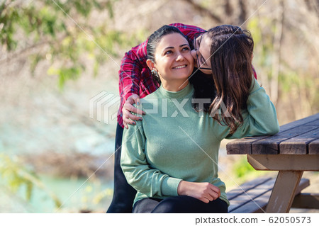 Mother and daughter enjoing their relationship in a park with a nice weather. Mother and daughter enjoing their relationship in a park with a nice weather. 62050573