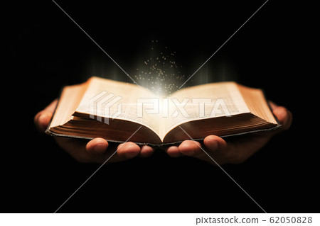Man holds holy bible book on black background. 62050828