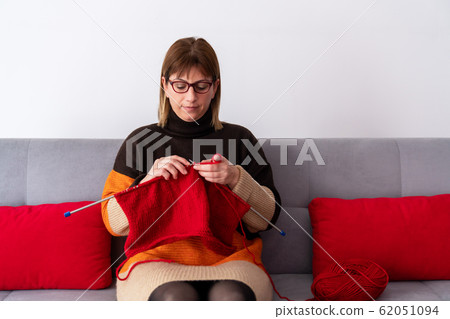 Handwork concept, young woman is knitting a needlework 62051094
