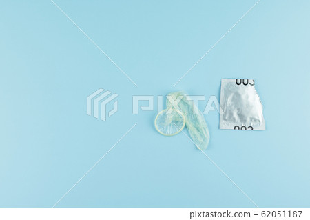 Used condom on blue background. Healthcare, safe Used condom on blue background. Healthcare, safe 62051187