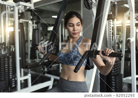 Young asian woman lifting barbell in gym. Young asian woman lifting barbell in gym. 62052293