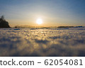 Winter frosty day. The time of sunset. Bokeh snowflakes sparkle in the sun 62054081