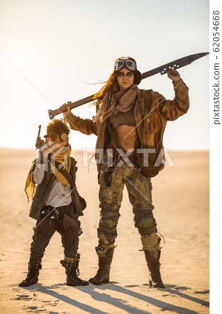 Post-apocalyptic Woman and Boy Outdoors in a Wasteland Post-apocalyptic Woman and Boy Outdoors in a Wasteland 62054668