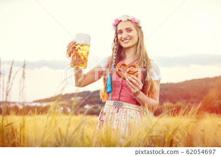 Happy Bavarian woman with beer and traditional food in summer 62054697
