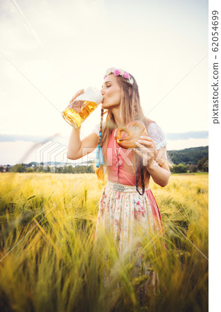 Woman in traditional clothing drinking beer in Bavaria 62054699