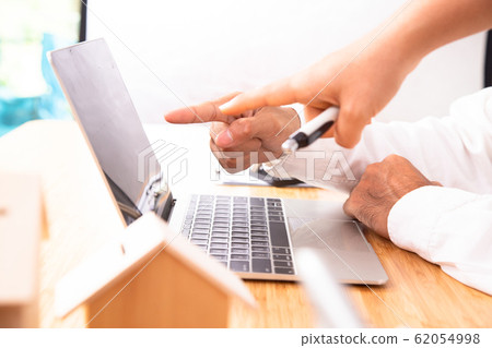 Close-up of business people pointing at laptop monitor together. Business People Working on Laptop. 62054998